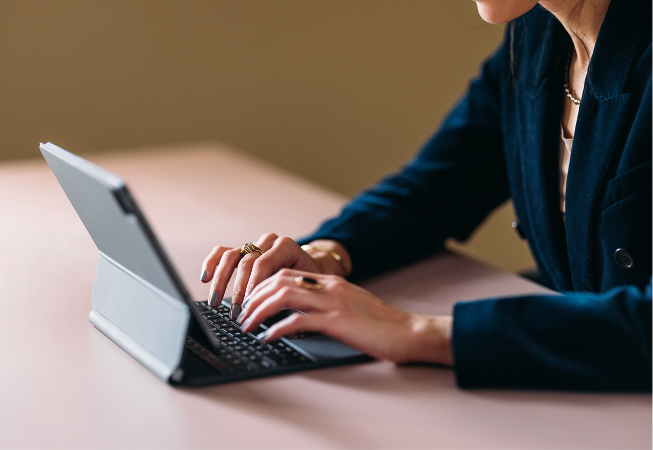 Woman typing on digital tablet