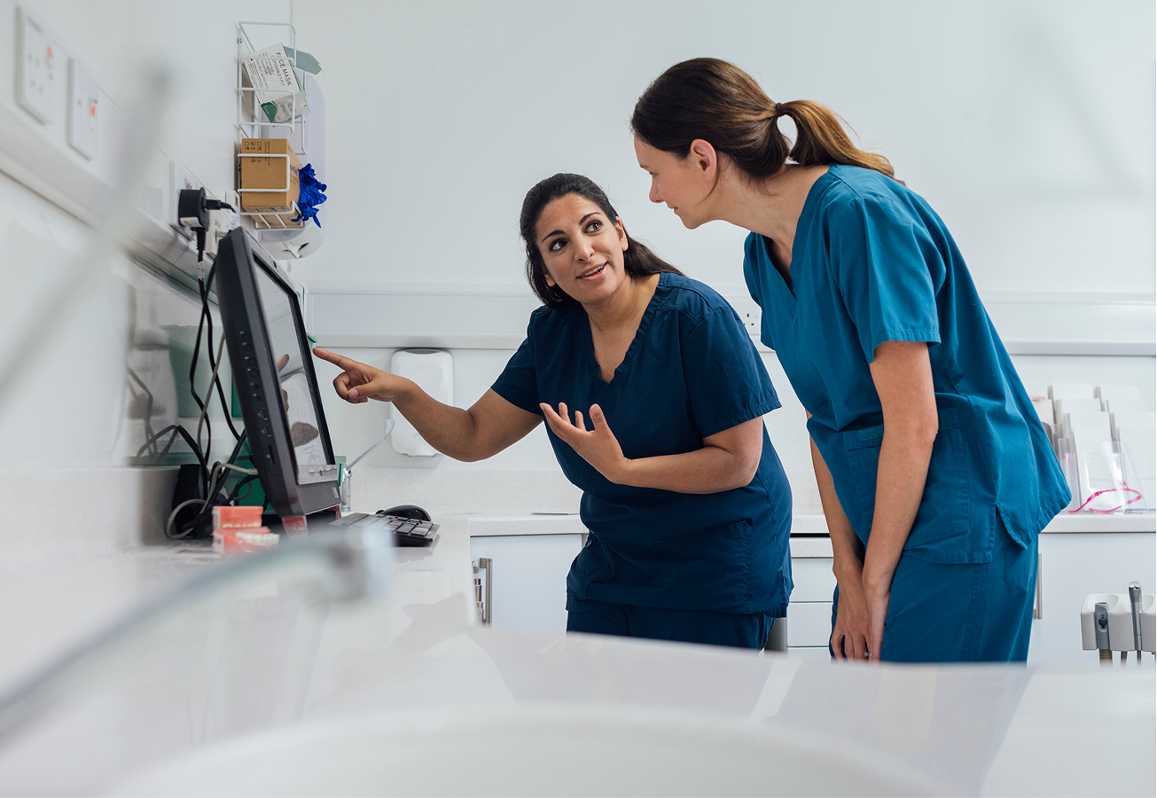 Two doctors reviewing a screen in a hospital environment.